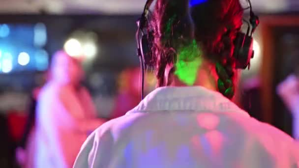 Задняя Часть Диджея Наушниках Белой Куртке Играющей Клубную Музыку Разноцветными — стоковое видео
