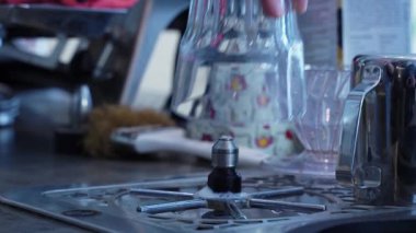 Kirli cam bardağı bulaşık makinesiyle yıkayan bir kızın yakın çekimi. Bir kafede kirli bardakları yıkamak. Kirli tabakların sterilizasyonu. Yüksek kalite 4k görüntü