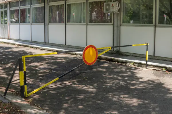 Siyah ve sarı bir metal bariyer ve yol çıkışını kapatan bir tabela. Yüksek kalite fotoğraf