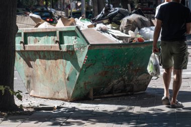 Şehir merkezinde metal bir çöp konteynırı. Çevre kirliliği. Yüksek kalite fotoğraf