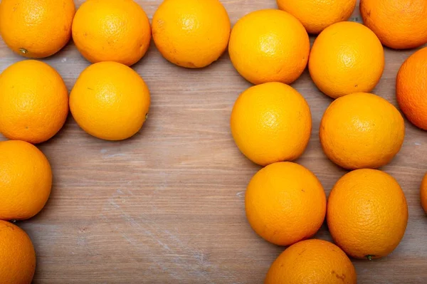 Turuncu Olgun Portakallar Büyük Miktarlarda Ahşap Bir Masanın Üzerinde Yatar — Stok fotoğraf