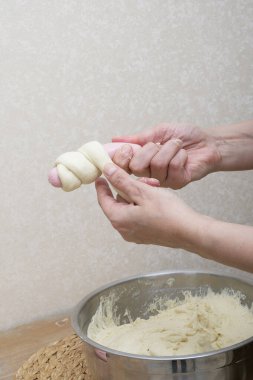 Kadınların elleri, ev mutfağındaki hamuru sıcak çiftlik evindeki duvarın yanındaki ahşap masada yoğuruyor. Kadın eli ve sosisli sandviç yapmak için. Diyet günü yok.