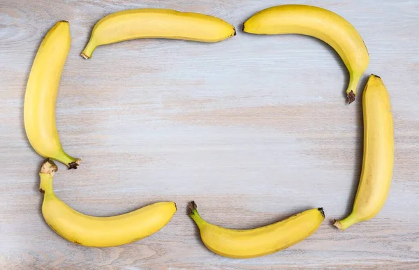 Желтые Спелые Бананы Выкладываются Рамку Текста Деревянной Текстурированной Поверхности Вид — стоковое фото