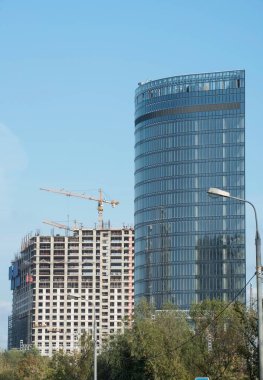 Büyük, modern bir iş merkezinin kompleksi inşa ediliyor. Bir bina zaten inşa edilmiş, ikincisi ise yapım aşamasında ve yüksek bir inşaat kulesi vinci var..