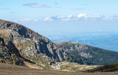 Dağların muhteşem manzarası. Dağlarda bir doğa rezervi ve ayna ilkbaharı açık mavi gökyüzünün altında beyaz kabarık bulutlar neşe, rahatlama, yoga ve seyahat için harika bir yer..