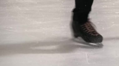 Artistik patinajcı kazı kazan yapıyor. Patenlerin yakın plan çekimi..