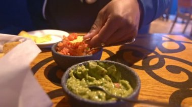 Nacho cipslerini salsa sosuna ve guacamole sosuna batırıyorum.