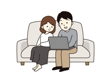 A couple sitting on the sofa and looking at a laptop.