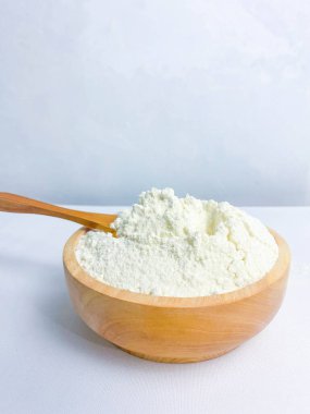 Tahta bir kase un ve un kaşığı izole edilmiş beyaz arka planda..