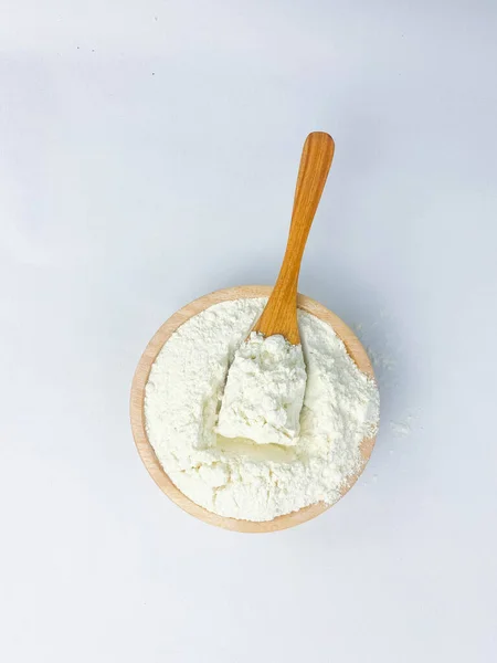 Stock image A wooden bowl of flour and flour spoon on an isolated white background.