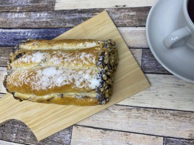 Eski ahşap arka planda bir fincan çayla servis edilen ekmek..