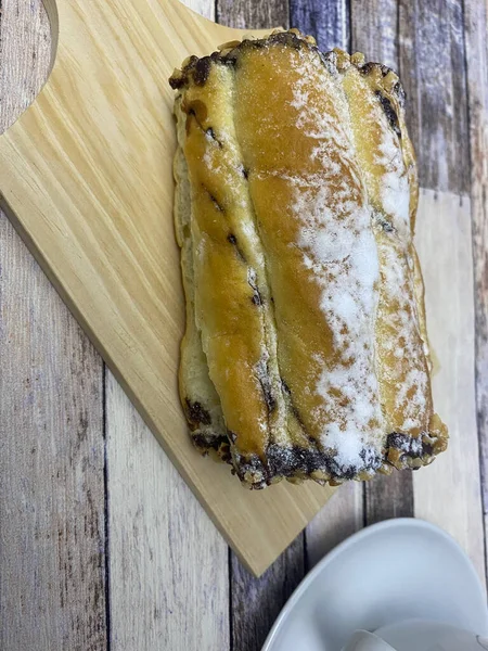 Eski ahşap arka planda bir fincan çayla servis edilen ekmek..