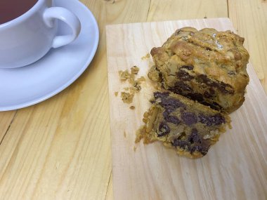 Kurabiyeler ahşap arka planda bir fincan çayla servis edilir..