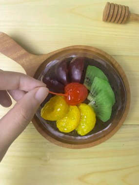 Üzerinde portakallar, üzümler, kivi ve kırmızı kirazlar olan çikolatalı pasta..