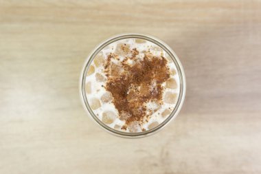 Süt köpüğüyle ahşap masada buz kapuçino.