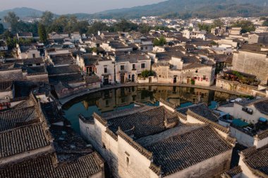 Tarihi köyde, kültür mirası ve güzelliği yansıtan sakin bir göleti çevreleyen süslü çatıları olan geleneksel Çin binaları bulunuyor..