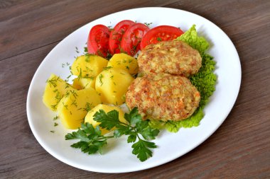 Pirinç ve lahana dilimlenmiş pirzola, patates ve domates.