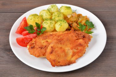 Patatesli tavuk filetosu, salata ve domates.