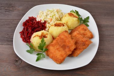Patates ve salatayla kızartılmış Miruna balığı.