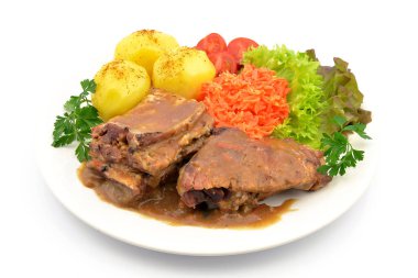 Patatesli domuz kaburgası, salata ve domates.