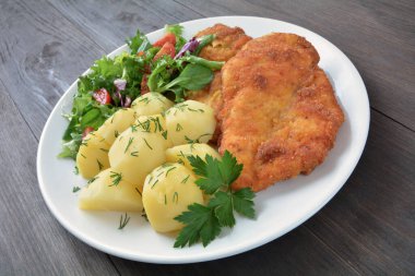 Patates ve salatalı kızarmış tavuk filetosu.