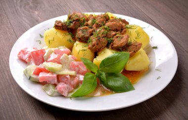 Patates ve salatayla pişirilmiş domuz eti.