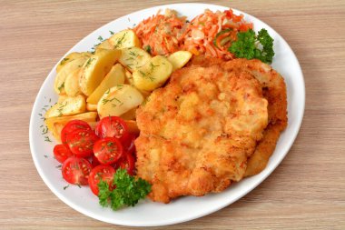 Domuz pirzolası, fırında patates, domates ve salata.