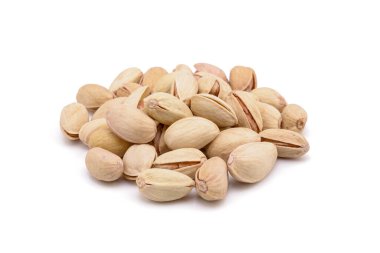 Beyaz zemin üzerinde kavrulmuş tuzlu şam fıstığı.