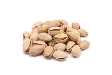 Beyaz zemin üzerinde kavrulmuş tuzlu şam fıstığı.