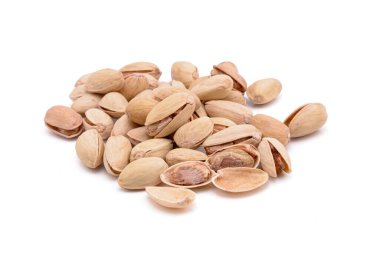 Beyaz zemin üzerinde kavrulmuş tuzlu şam fıstığı.