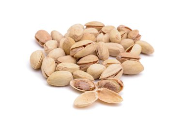 Beyaz zemin üzerinde kavrulmuş tuzlu şam fıstığı.