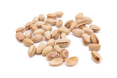 Beyaz zemin üzerinde kavrulmuş tuzlu şam fıstığı.