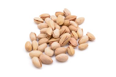 Beyaz zemin üzerinde kavrulmuş tuzlu şam fıstığı.