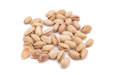 Beyaz zemin üzerinde kavrulmuş tuzlu şam fıstığı.