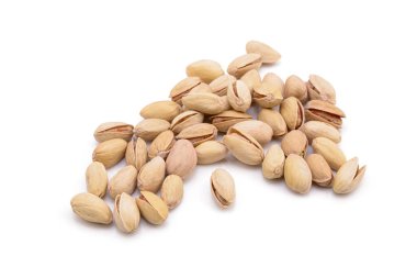 Beyaz zemin üzerinde kavrulmuş tuzlu şam fıstığı.