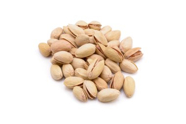 Beyaz zemin üzerinde kavrulmuş tuzlu şam fıstığı.