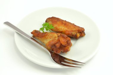 Beyaz arka planda izole edilmiş fırında tavuk kanatları.