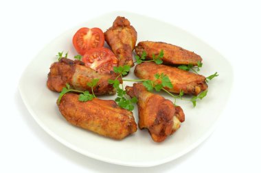 Beyaz arka planda izole edilmiş fırında tavuk kanatları.