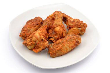 Beyaz arka planda izole edilmiş fırında tavuk kanatları.