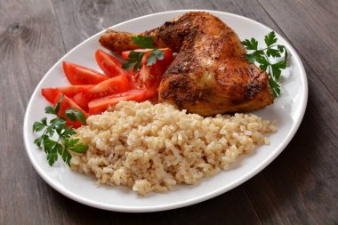 baked chicken leg with rice and tomato