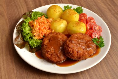 minced cutlet with potatoes, salad and tomato