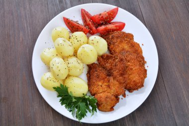 Patates ve domatesli kızarmış tavuk filetosu.