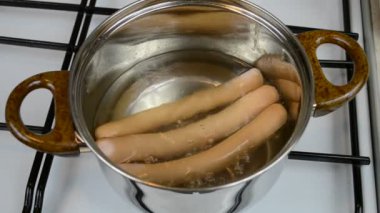 Tencerede sosis pişirmek.
