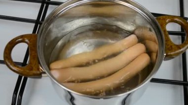 Tencerede sosis pişirmek.