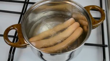 Tencerede sosis pişirmek.
