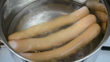 Tencerede sosis pişirmek.