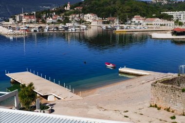 Küçük Adriyatik kasabası Melinje, Karadağ 'daki Herceg Novi, yeşil palto, taş binalar, çakıl taşı plajı, balıkçı tekneleri, yatlı marina manzarası