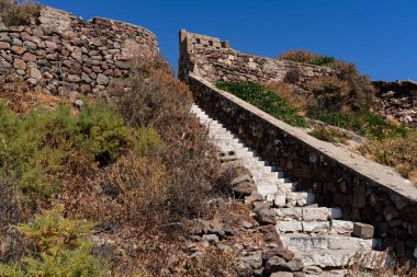 Ortaçağ Venedik Kalesi 'nin taş merdivenleri, kaya duvarları, tarihi mimari, Milos Adası Körfezi manzarası