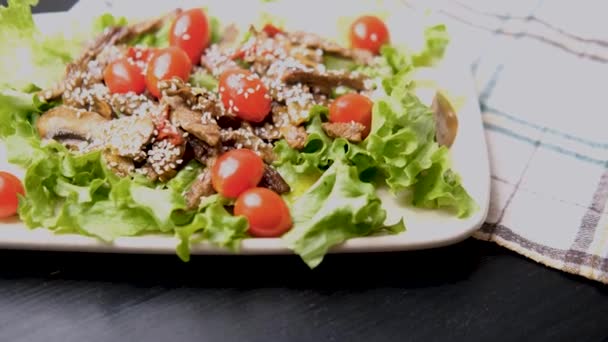 Warmer Fleischsalat Mit Sesamdressing Tellerrotation Grünen Salatblättern Kirschtomaten Rindfleischscheiben Schwarzem — Stockvideo