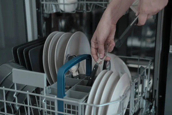 妇女的手在全自动洗碗机上放割线 洗碗机上有白色和黑色的灰色盘子 家常便饭 — 图库照片